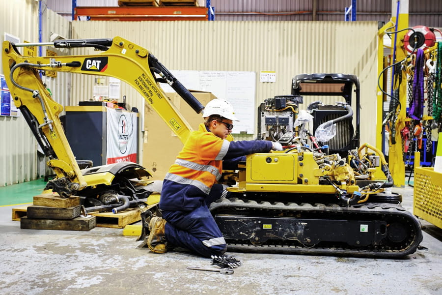 WesTrac employee working on excavator in Canberra workshop