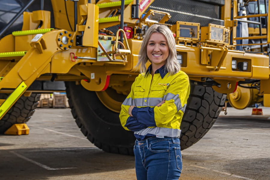 Female WesTrac employee standing in front of a mining truck