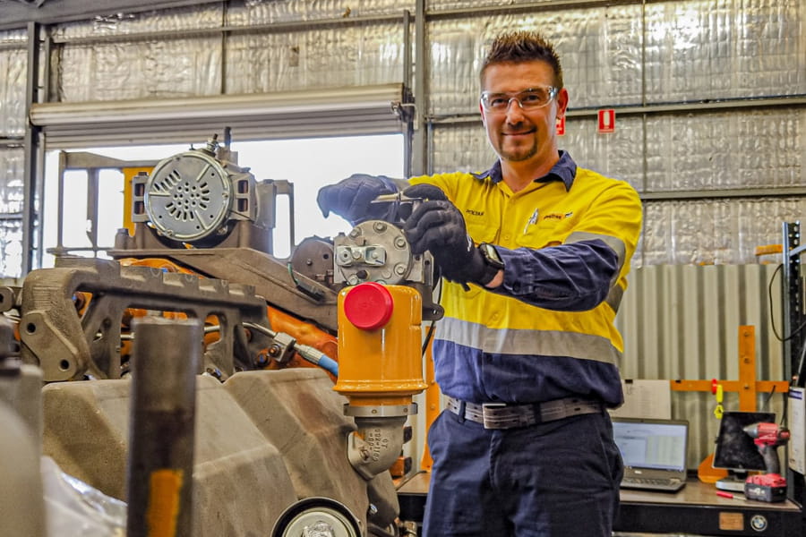 WesTrac employee in PPE smiling in a workshop