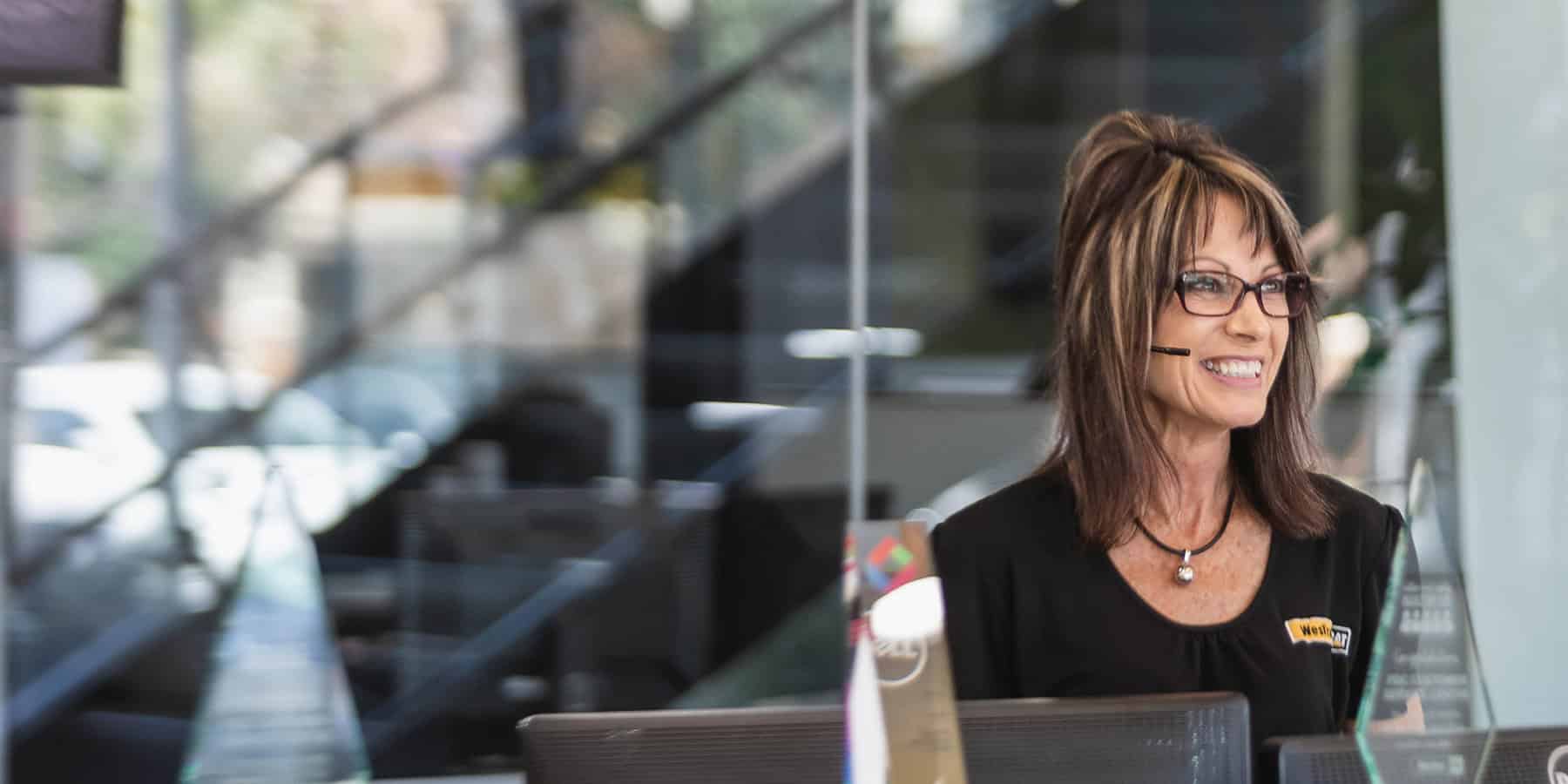 female team member at reception smiling