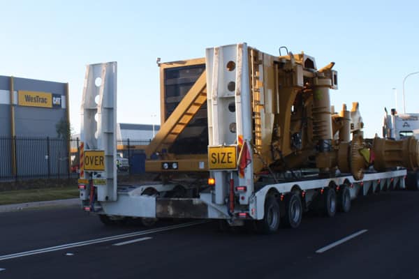 back of a truck carrying a machine