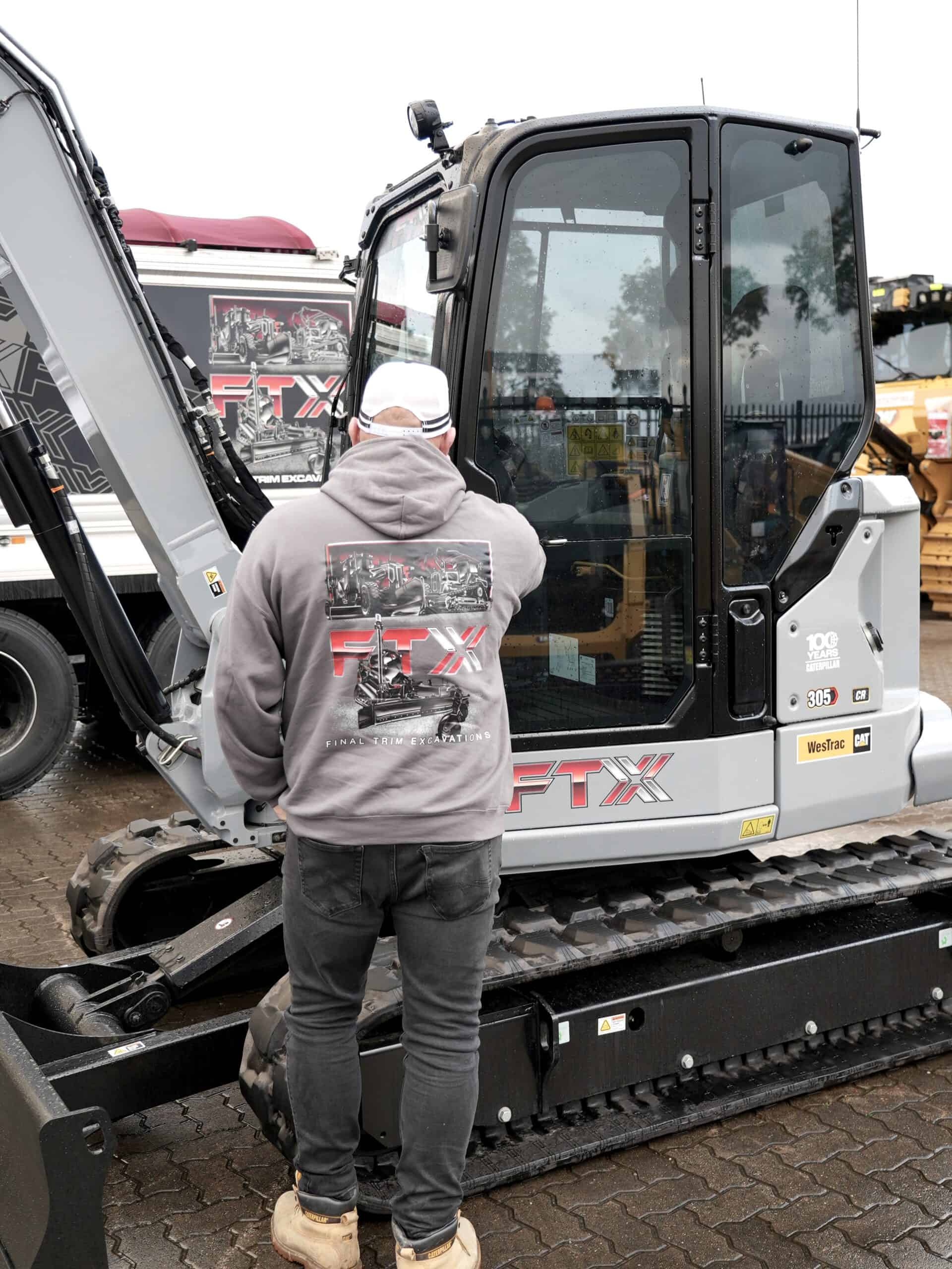 Tom Campbell from FTX looking at his new Cat Centennial Grey Mini Excavator
