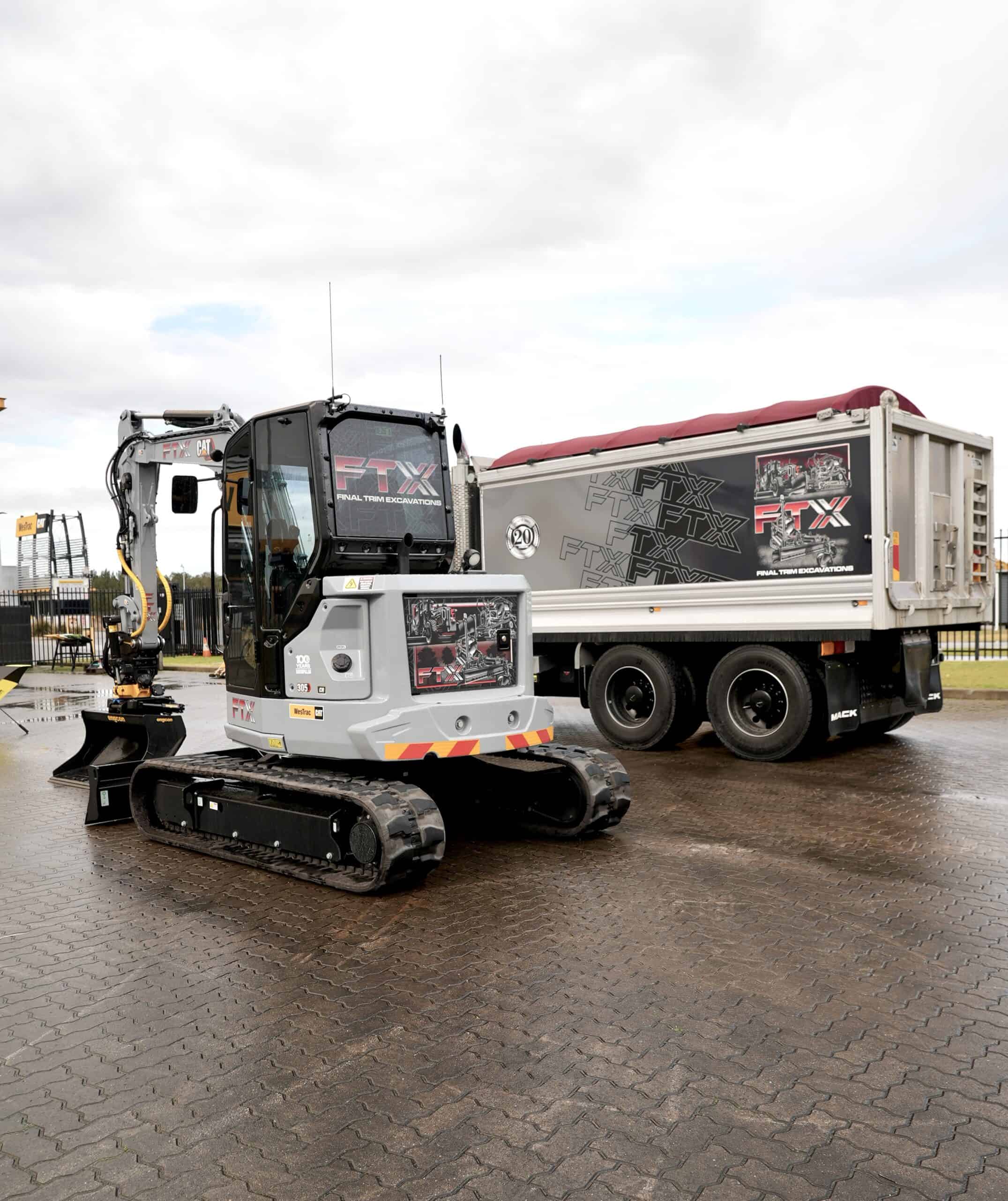 FTX Centennial Grey Cat Mini Excavator next to truck